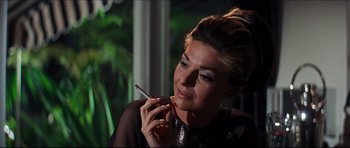 Movie still from “The Graduate” (1967), directed by Mike Nichols – A beautiful woman smoking a cigarette while wearing a black dress; Close Up shot, Over the shoulder angle
