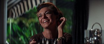 Movie still from “The Graduate” (1967), directed by Mike Nichols – A woman smiling while talking on a cell phone; Close Up shot, Low angle