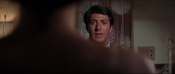 Movie still from “The Graduate” (1967), directed by Mike Nichols – A man's face in a dark room; Close Up shot, Over the shoulder angle