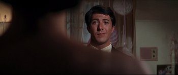 Movie still from “The Graduate” (1967), directed by Mike Nichols – A person wearing a suit and tie; Close Up shot, Over the shoulder angle