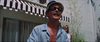 Movie still from “The Graduate” (1967), directed by Mike Nichols – A person wearing sunglasses and a hat; Medium shot, Low angle