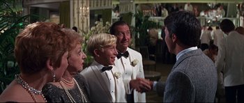 Movie still from “The Graduate” (1967), directed by Mike Nichols – A group of people standing next to each other in tuxedos; Medium shot, Over the shoulder angle