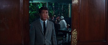Movie still from “The Graduate” (1967), directed by Mike Nichols – A man in a suit standing in front of a table; Medium shot, Over the shoulder angle