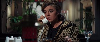 Movie still from “The Graduate” (1967), directed by Mike Nichols – A woman talking on a phone while sitting at a table; Close Up shot, High angle