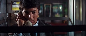 Movie still from “The Graduate” (1967), directed by Mike Nichols – A man in a suit is talking on a phone; Close Up shot, Low angle