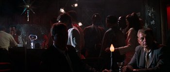 Movie still from “The Graduate” (1967), directed by Mike Nichols – A group of men standing around a room; Wide shot, Over the shoulder angle