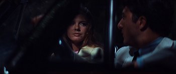 Movie still from “The Graduate” (1967), directed by Mike Nichols – A woman looking into a mirror while standing next to a man; Close Up shot, Over the shoulder angle