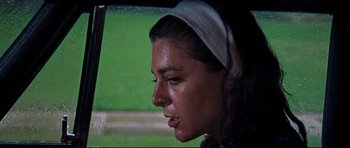 Movie still from “The Graduate” (1967), directed by Mike Nichols – A person wearing a headscarf looking out a window; Close Up shot, Low angle