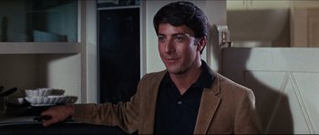 Movie still from “The Graduate” (1967), directed by Mike Nichols – A man in a brown jacket and black shirt; Close Up shot, Over the shoulder angle