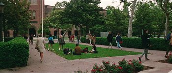 Movie still from “The Graduate” (1967), directed by Mike Nichols – A group of people sitting on the grass near a building; Extreme Wide shot, High angle