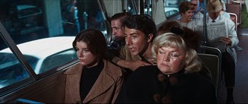 Movie still from “The Graduate” (1967), directed by Mike Nichols – A group of people sitting on a bus together; Medium shot, Over the shoulder angle