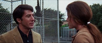 Movie still from “The Graduate” (1967), directed by Mike Nichols – A man and a woman talking in front of a chain link fence; Close Up shot, Over the shoulder angle