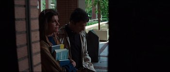 A man and a woman sitting next to each other holding books