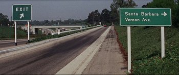 Movie still from “The Graduate” (1967), directed by Mike Nichols – A street sign on the side of a road; Extreme Wide shot, High angle
