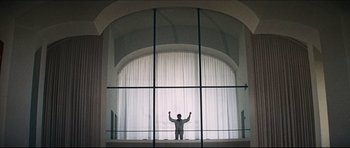 Movie still from “The Graduate” (1967), directed by Mike Nichols – A man standing in front of an arched window; Wide shot, Low angle