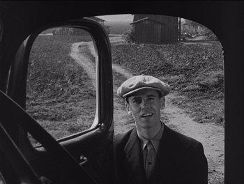 Movie still from “The Grapes of Wrath” (1940), directed by John Ford – A black and white photo of a man in a car; Medium shot, Low angle