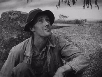 Movie still from “The Grapes of Wrath” (1940), directed by John Ford – Black and white photograph of a man sitting on the ground; Close Up shot, Low angle