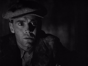 Movie still from “The Grapes of Wrath” (1940), directed by John Ford – A black and white photo of a man wearing a hat; Close Up shot, Low angle