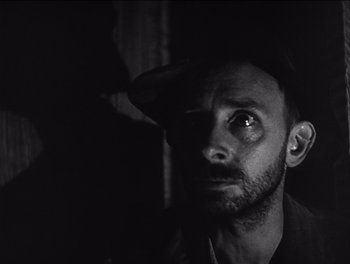 Movie still from “The Grapes of Wrath” (1940), directed by John Ford – A black and white photo of a man with a hat on; Close Up shot, Low angle