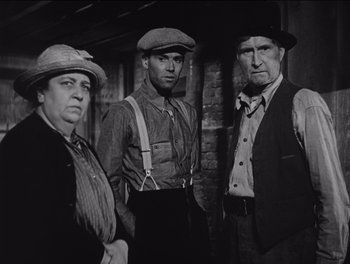 Movie still from “The Grapes of Wrath” (1940), directed by John Ford – A black and white photo of three men standing together; Medium shot, Low angle