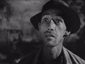 Movie still from “The Grapes of Wrath” (1940), directed by John Ford – A black and white photo of a man wearing a hat; Close Up shot, Low angle