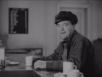 Movie still from “The Grapes of Wrath” (1940), directed by John Ford – An older man sitting at a table with a cup of coffee in front of him; Medium shot, Over the shoulder angle