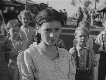 Movie still from “The Grapes of Wrath” (1940), directed by John Ford – A group of people standing in front of each other; Medium shot, Low angle