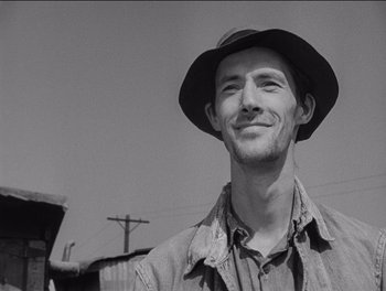 Movie still from “The Grapes of Wrath” (1940), directed by John Ford – A black and white photo of a man wearing a hat; Close Up shot, Low angle