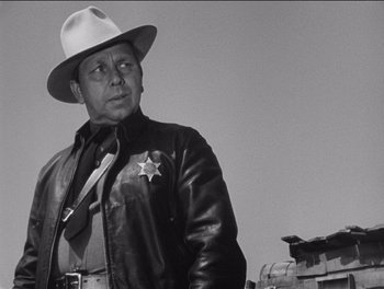 Movie still from “The Grapes of Wrath” (1940), directed by John Ford – A man in a leather jacket and a hat; Medium shot, Low angle
