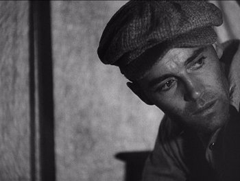 Movie still from “The Grapes of Wrath” (1940), directed by John Ford – A black and white photo of a man wearing a hat; Close Up shot, Over the shoulder angle