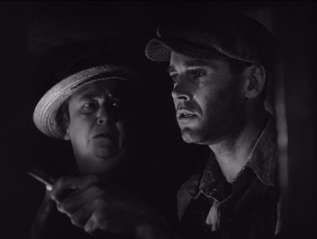 Movie still from “The Grapes of Wrath” (1940), directed by John Ford – Two men are looking at each other while holding a cigarette; Close Up shot, Low angle