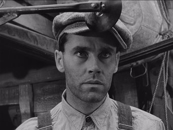 Movie still from “The Grapes of Wrath” (1940), directed by John Ford – A black and white photo of a man wearing a hat and suspenders; Close Up shot, Low angle