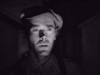 Movie still from “The Grapes of Wrath” (1940), directed by John Ford – A black and white photo of a man wearing a hat; Close Up shot, Low angle