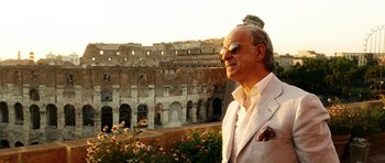 Movie still from “The Great Beauty” (2013), directed by Paolo Sorrentino – An older man in a white suit standing in front of a building; Medium shot, Low angle