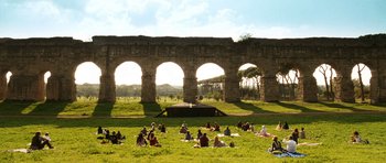 Movie still from “The Great Beauty” (2013), directed by Paolo Sorrentino – A group of people sitting in the grass near a wall; Extreme Wide shot, High angle