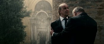 Movie still from “The Great Beauty” (2013), directed by Paolo Sorrentino – A man in a suit and tie standing in front of a fountain; Medium shot, Over the shoulder angle