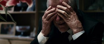 Movie still from “The Great Beauty” (2013), directed by Paolo Sorrentino – An older man in a black suit and white shirt holding his hands to his face; Close Up shot, Over the shoulder angle