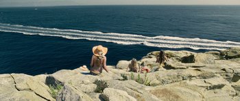 Movie still from “The Great Beauty” (2013), directed by Paolo Sorrentino – A group of people sitting on top of a rock near the ocean; Extreme Wide shot, High angle