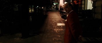 Movie still from “The Great Beauty” (2013), directed by Paolo Sorrentino – A man in a red suit standing on the sidewalk; Medium shot, Over the shoulder angle