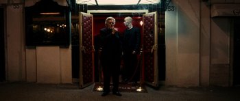 Movie still from “The Great Beauty” (2013), directed by Paolo Sorrentino – A man standing next to another man in a suit; Wide shot, Low angle