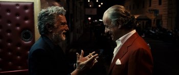 Movie still from “The Great Beauty” (2013), directed by Paolo Sorrentino – Two older men talking and smoking a cigarette together; Close Up shot, Over the shoulder angle