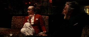 Movie still from “The Great Beauty” (2013), directed by Paolo Sorrentino – An older man sitting on a couch smoking a cigarette; Medium shot, Over the shoulder angle