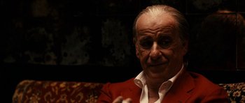 Movie still from “The Great Beauty” (2013), directed by Paolo Sorrentino – An older man sitting on a couch in a room; Close Up shot, Over the shoulder angle