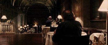 Movie still from “The Great Beauty” (2013), directed by Paolo Sorrentino – A group of people sitting at tables with wine glasses on it; Wide shot, Over the shoulder angle
