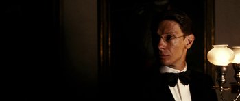 Movie still from “The Great Beauty” (2013), directed by Paolo Sorrentino – A man wearing a suit and tie in a dark room; Close Up shot, Low angle