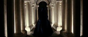 Movie still from “The Great Beauty” (2013), directed by Paolo Sorrentino – A woman in a long black dress standing in front of pillars; Wide shot, Low angle