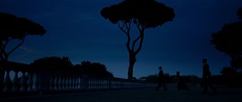 Movie still from “The Great Beauty” (2013), directed by Paolo Sorrentino – A person walking in front of a tree at night; Extreme Wide shot, Low angle