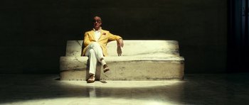 Movie still from “The Great Beauty” (2013), directed by Paolo Sorrentino – A man sitting on steps wearing a yellow jacket; Wide shot, Low angle