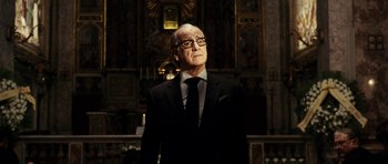 Movie still from “The Great Beauty” (2013), directed by Paolo Sorrentino – An older man wearing a suit and tie in front of a wall; Close Up shot, Low angle
