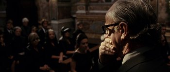 Movie still from “The Great Beauty” (2013), directed by Paolo Sorrentino – An old man wearing glasses is looking down at his face; Close Up shot, Over the shoulder angle